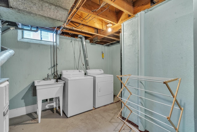 washroom with laundry area, a sink, and washing machine and clothes dryer