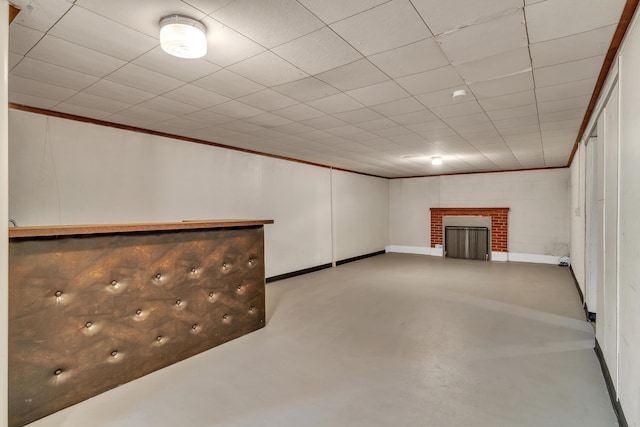 finished basement with crown molding and a fireplace