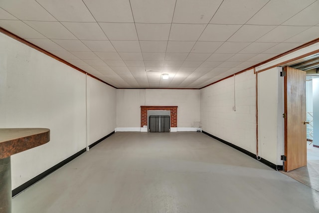 finished basement with crown molding, a fireplace, and baseboards