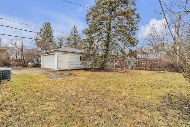 view of yard with a detached garage, central AC unit, and an outbuilding