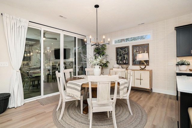 dining area featuring light wood finished floors and a chandelier