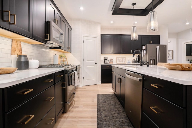 kitchen featuring stainless steel appliances, a sink, and dark cabinets