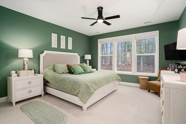 bedroom featuring light carpet, a ceiling fan, visible vents, and baseboards