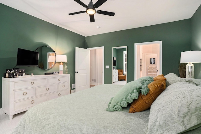 carpeted bedroom featuring connected bathroom, visible vents, and ceiling fan