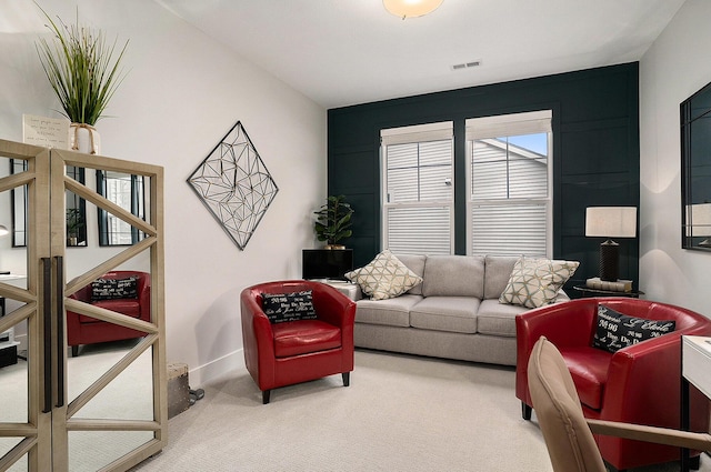 living area with baseboards, visible vents, and carpet flooring