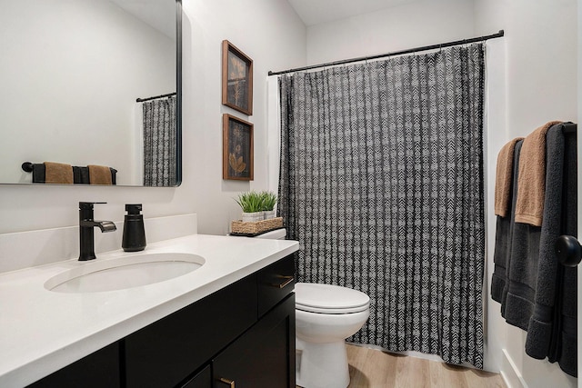 bathroom featuring vanity, toilet, and wood finished floors