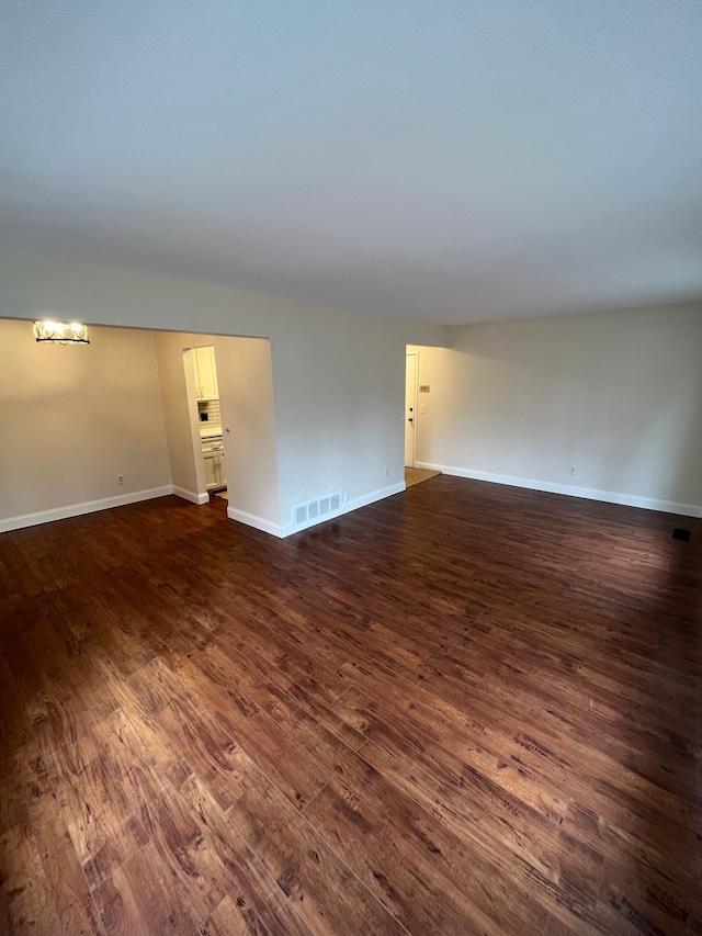 interior space featuring dark wood-type flooring, visible vents, and baseboards