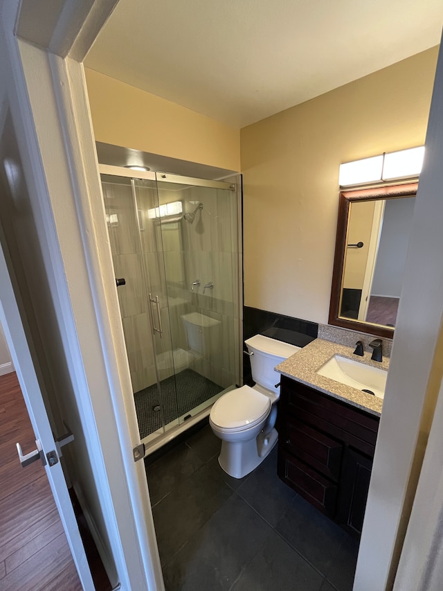 bathroom featuring a stall shower, vanity, toilet, and tile patterned floors