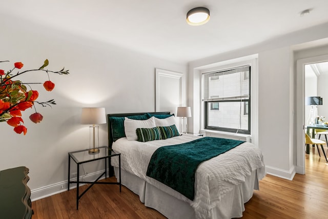 bedroom featuring baseboards and wood finished floors