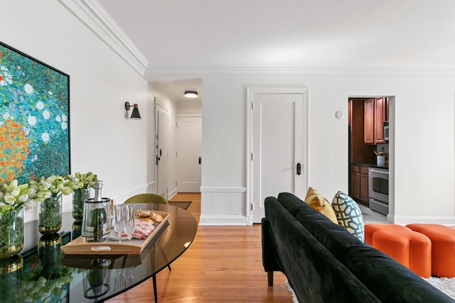 living room with light wood-type flooring, baseboards, and crown molding