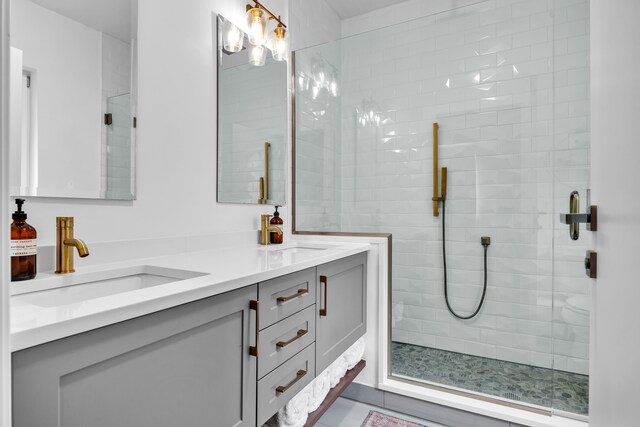 bathroom featuring double vanity, a shower stall, and a sink