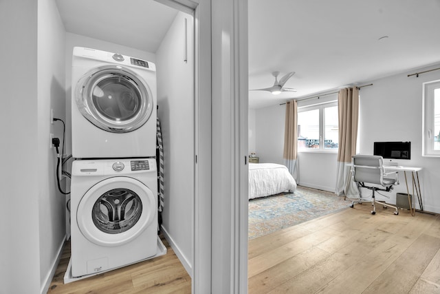 washroom with ceiling fan, stacked washer and dryer, light wood-style flooring, and laundry area