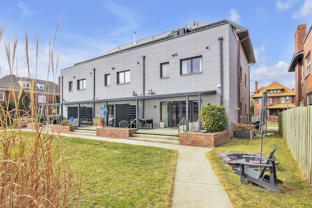 rear view of property featuring a lawn and a fenced backyard