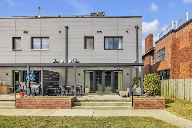 rear view of house featuring a patio and fence