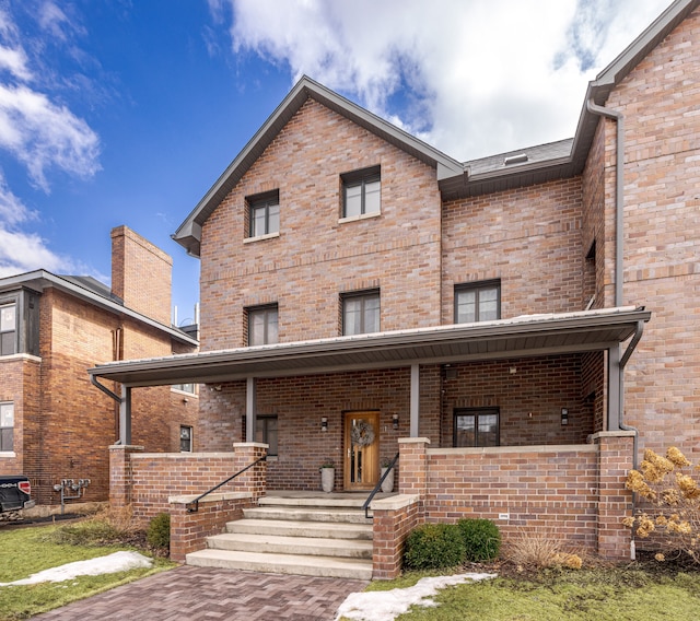 view of front of property with covered porch and brick siding