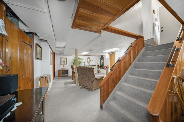 carpeted living room with stairway and a drop ceiling