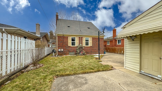 back of property with a patio area, brick siding, a lawn, and a fenced backyard