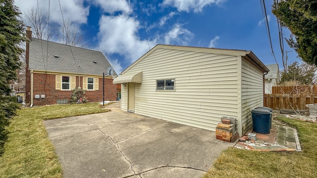 rear view of property with a yard, brick siding, a patio area, and fence