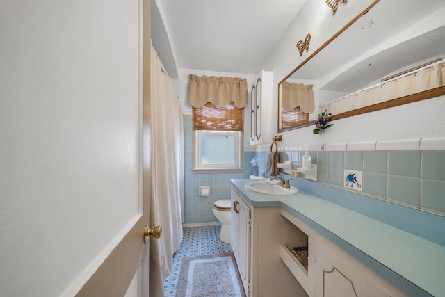 bathroom with toilet, a shower with shower curtain, vanity, tile walls, and tile patterned floors