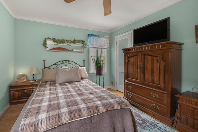 bedroom with light wood-style floors, crown molding, baseboards, and a ceiling fan