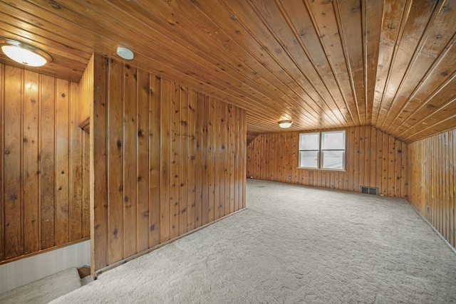 additional living space featuring wood walls, wood ceiling, and visible vents