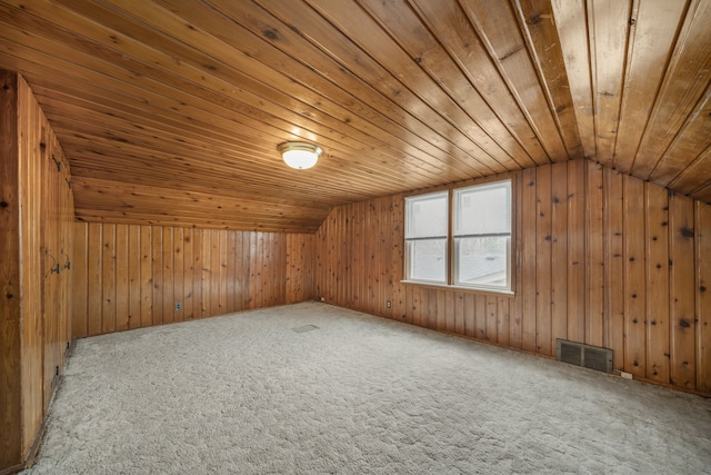 bonus room with lofted ceiling, visible vents, carpet flooring, wooden walls, and wooden ceiling