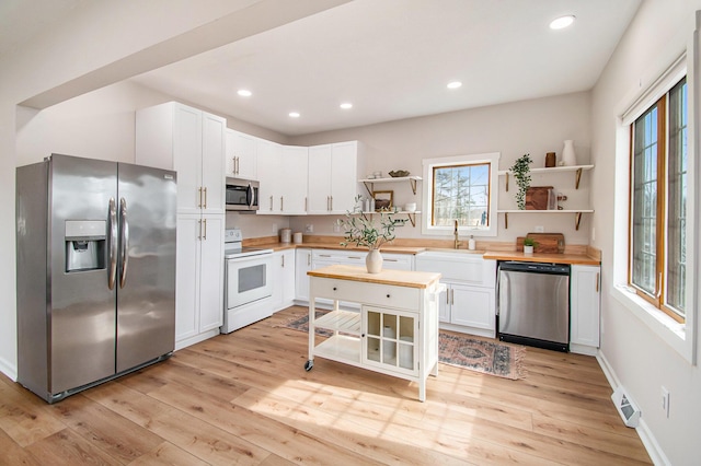 kitchen featuring open shelves, stainless steel appliances, white cabinets, wood counters, and light wood-type flooring