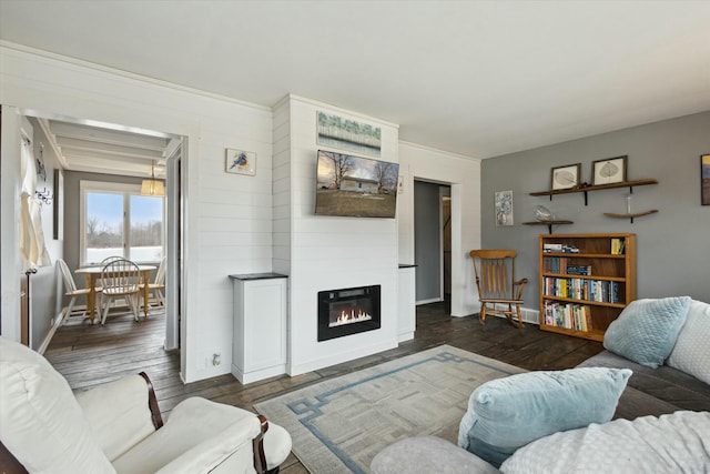 living area with a fireplace, baseboards, and dark wood finished floors