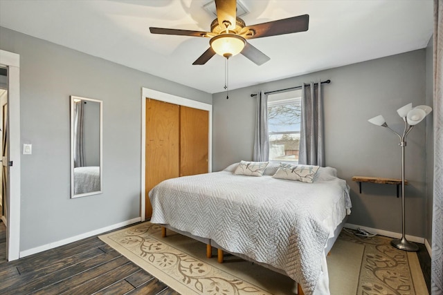 bedroom featuring a ceiling fan, a closet, baseboards, and wood finished floors