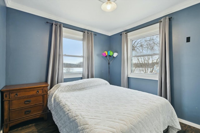 bedroom featuring baseboards, dark wood finished floors, and crown molding