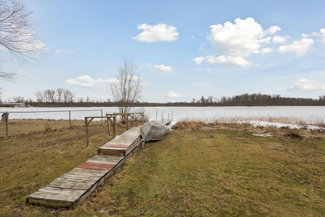 dock area featuring fence and a lawn