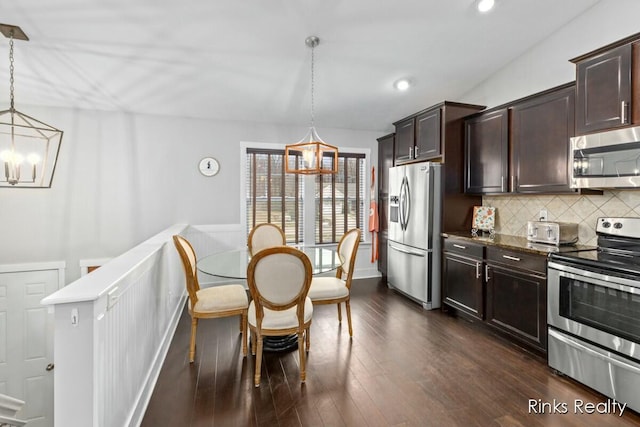 kitchen with dark brown cabinetry, a chandelier, stainless steel appliances, and dark wood finished floors