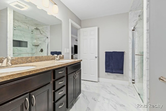 bathroom with marble finish floor, a sink, and a marble finish shower