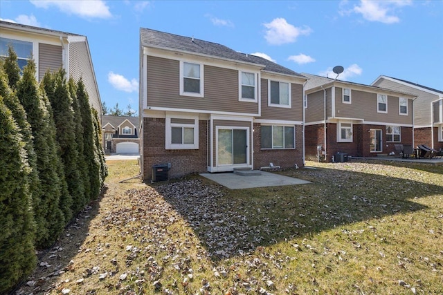 back of house with a yard, brick siding, central AC unit, and a patio area