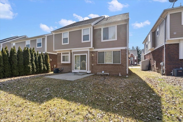 back of house featuring central air condition unit, a patio area, and brick siding