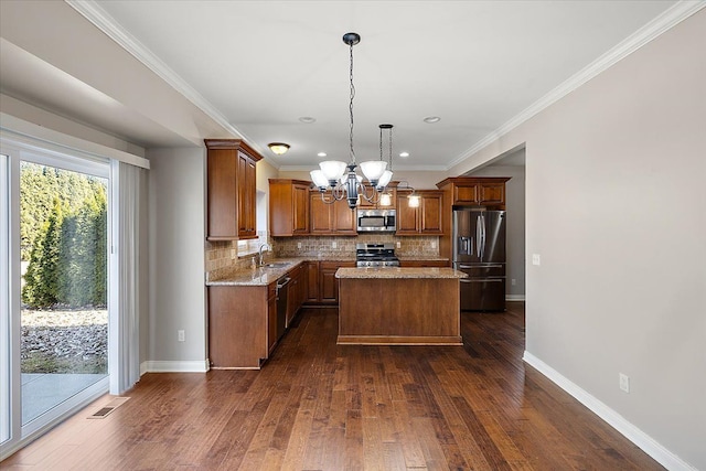 kitchen with dark wood-type flooring, backsplash, appliances with stainless steel finishes, and a sink