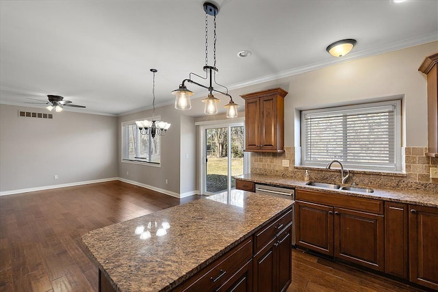 kitchen featuring visible vents, ornamental molding, a sink, tasteful backsplash, and dark wood finished floors