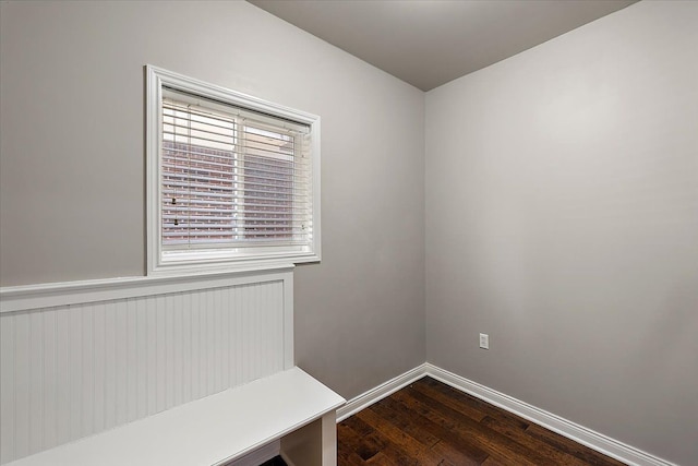 mudroom featuring dark wood-type flooring and baseboards