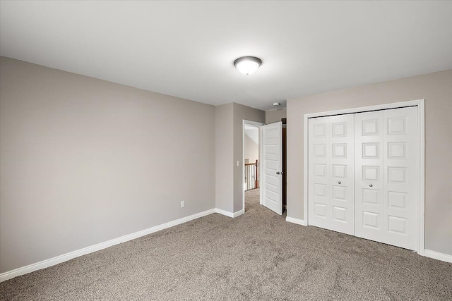 unfurnished bedroom with a closet, baseboards, and carpet