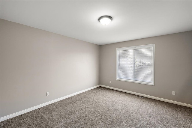 empty room with visible vents, baseboards, and carpet floors