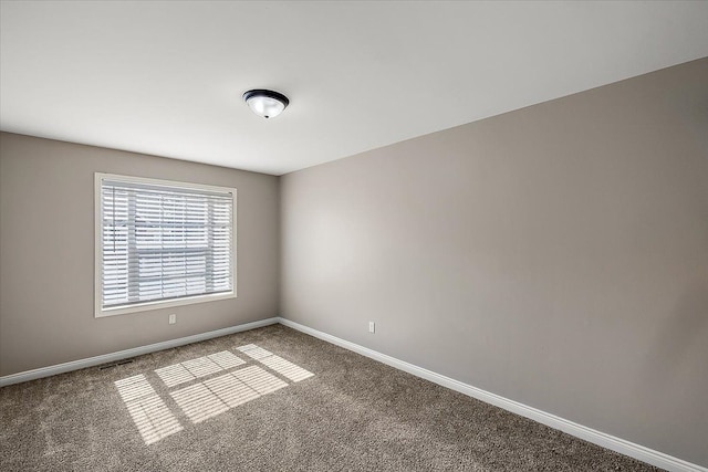 carpeted empty room featuring visible vents and baseboards