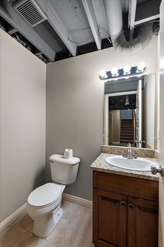 half bathroom with visible vents, toilet, vanity, and baseboards