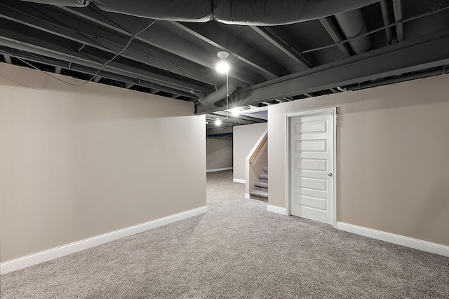 finished basement featuring stairway, baseboards, and carpet floors