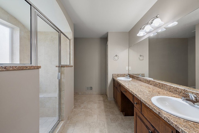 full bath with a shower stall, double vanity, visible vents, and a sink