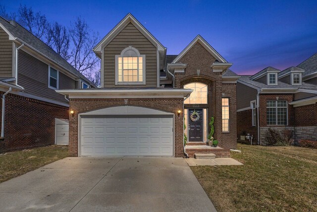 traditional-style home featuring brick siding, concrete driveway, and a garage