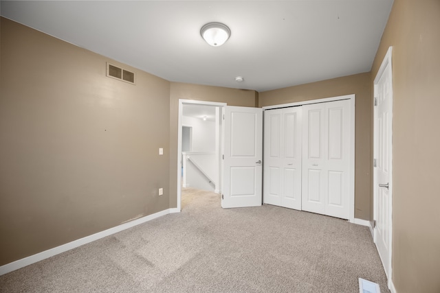 unfurnished bedroom with carpet floors, a closet, visible vents, and baseboards