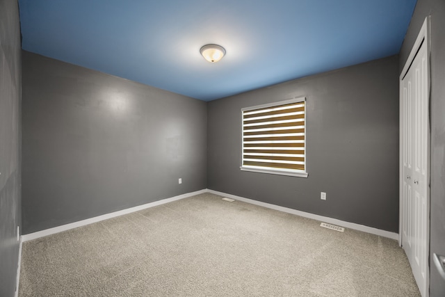 unfurnished room featuring carpet floors and baseboards