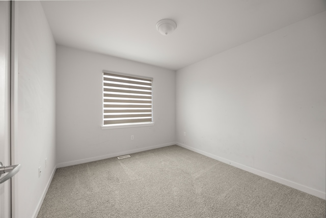 unfurnished room with carpet flooring, visible vents, and baseboards