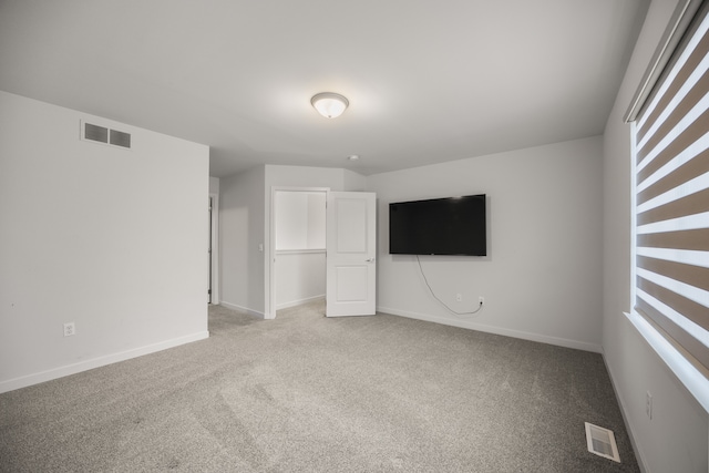 unfurnished bedroom featuring carpet, visible vents, and baseboards