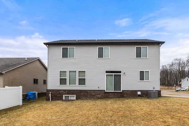 rear view of house with cooling unit and a lawn